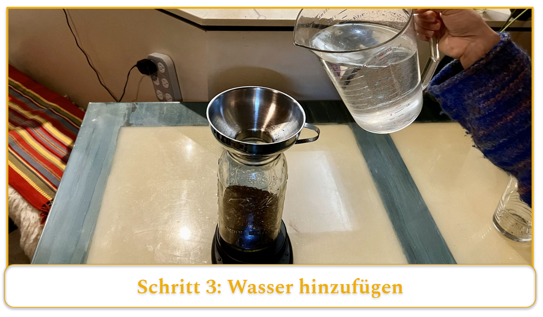step 3 of making cold brew coffee; adding water to coffee grounds using a funnel