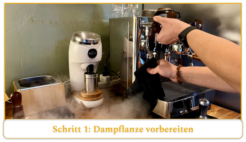 step 1 of using an espresso machine's steam wand; holding a towel to the tip of the steam wand and running it for 2-3 seconds