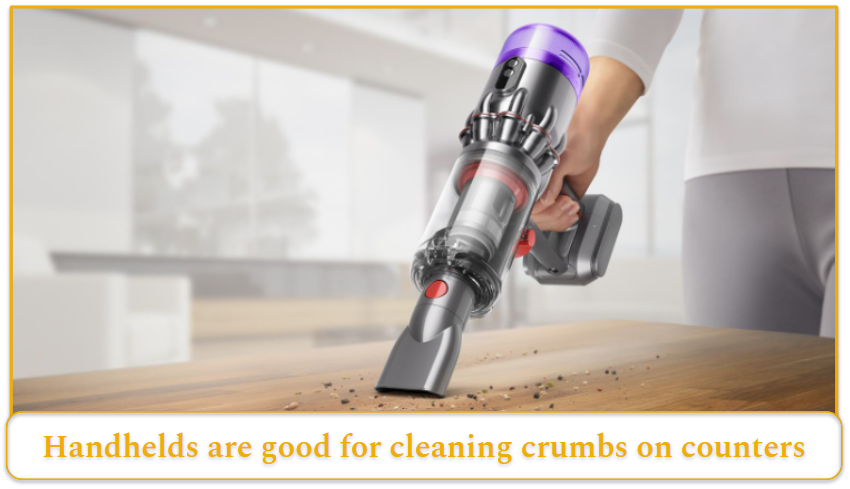 Handheld vacuum cleaning the crumbs off a table.
